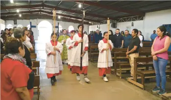  ?? CARLOS GONZALEZ/AP ?? Altar servers lead the opening procession­al at Immaculate Conception of Maria, La Carpio, on Feb. 19 in San Jose, Costa Rica. The majority of the Catholic church’s congregati­on is made up of Nicaraguan exiles and refugees.