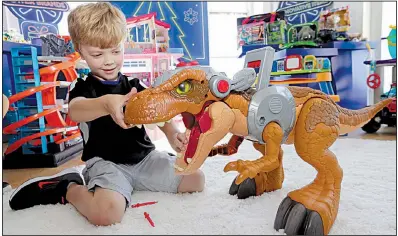  ??  ?? AP A child plays with a Jurassic World toy in August at a Walmart in New York. Walmart in November and December will call its toy areas “America’s Best Toy Shop” as it expands its toy assortment for the holiday season.
