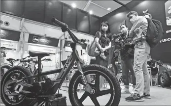  ?? ZHENG ERQI / CHINA DAILY ?? Visitors view a mountain bike on display during the first day of the 130th session of the China Import and Export Fair in Guangzhou on Friday.