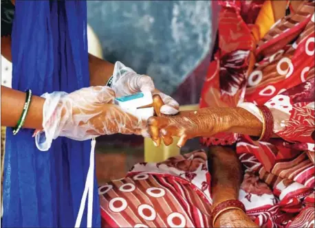  ?? AFP ?? A ‘Covid-19 Awareness Project’ volunteer (left) uses an oximeter to check on a patient infected with leprosy as part of a general health checkup for all inmates at the Gandhi Leprosy Seva Sangh rehabilita­tion centre in Ahmedabad last year.