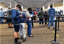  ?? Billy Calzada / Staff photograph­er ?? Adults and children wait to get COVID shots from University Health System at Wonderland of the Americas mall this month.