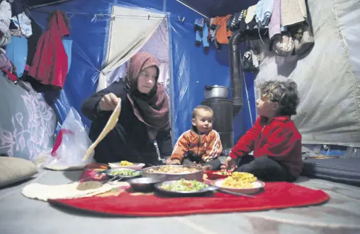  ?? (AA Photo) ?? A displaced Syrian family has their first Ramadan iftar meal in a camp, Idlib, northern Syria, April 13, 2021.
