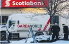  ??  ?? Police investigat­e the scene of Thursday’s holdup at a Scotiabank branch in northeast Edmonton.