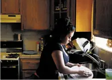  ?? Leah Millis / The Chronicle ?? Lizette Serrato, 25, does the dishes after dinner at her home in Tulare County. The family is coping after its well ran dry.