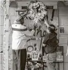  ?? Steve Gonzales / Staff photograph­er ?? Dr. Walter Pendleton and We The People founder Hai Bui hang a wreath at 7815 Harding during a January 2020 vigil on the anniversry of the botched raid that killed a couple.