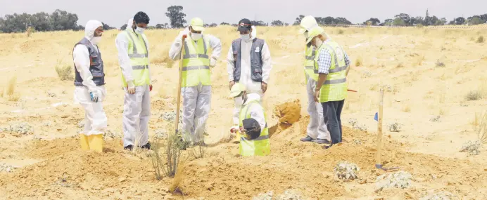  ??  ?? Members of the Government of National Accord’s (GNA) missing persons bureau search for human remains in mass graves discovered in areas liberated from Khalifa Haftar’s forces, in the city of Tarhuna, Libya, June 23, 2020.