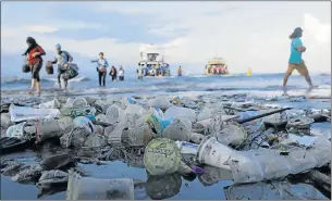  ?? Picture: AFP Picture: REUTERS ?? PLASTIC BEACH: Boat cruisers walk through plastic on a beach in Bali, Indonesia, right