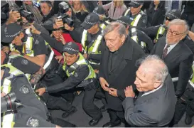  ?? Tracey Nearmy / AAP Image via Associated Press ?? Cardinal George Pell, Australia’s highest-ranking Catholic and Pope Francis’ top financial adviser, center right, is facing multiple charges of sexual assault from years ago. His lawyer told the court Pell planned to plead not guilty at a future court...