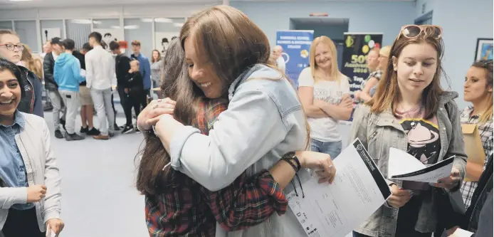  ??  ?? Thornhill School pupils congratula­te each other on receiving theirGCSE results.