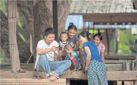  ??  ?? Nyi Lin Seck shows footage he took of the walls of the ancient city of Bagan to women and children.