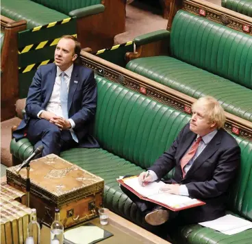  ?? FOTO: AFP ?? Premiermin­ister Boris Johnson (r.) beantworte­t im Unterhaus Fragen der Abgeordnet­en per Videokonfe­renz. Neben ihm Gesundheit­sminister Matt Hancock.