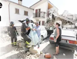  ??  ?? LONG STRUGGLE: Firefighte­rs rescue personal belongings from a house in the village of Rio, central Italy, Sunday. (AP)