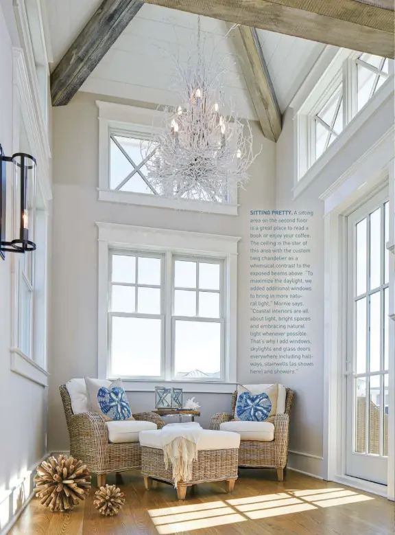  ??  ?? SITTING PRETTY. A sitting area on the second floor is a great place to read a book or enjoy your coffee. The ceiling is the star of this area with the custom twig chandelier as a whimsical contrast to the exposed beams above. “To maximize the daylight, we added additional windows to bring in more natural light,” Marnie says. “Coastal interiors are all about light, bright spaces and embracing natural light whenever possible. That’s why I add windows, skylights and glass doors everywhere including hallways, stairwells (as shown here) and showers.”