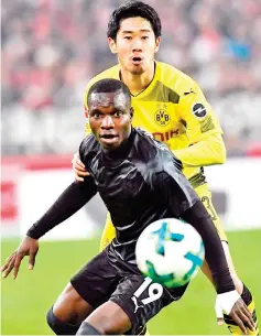  ?? — AFP photo ?? Stuttgart's Congolese forward Chadrac Akolo (L) and Dortmund's Japanese midfielder Shinji Kagawa vie for the ball during the German first division Bundesliga football match VfB Stuttgart vs BVB Borussia Dortmund in Stuttgart,southweste­rn Germany,on...