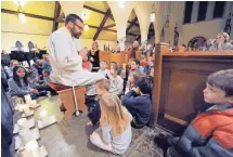  ?? MICHAEL MCLOONE / FOR THE JOURNAL SENTINEL ?? The Rev. Seth Dietrich calls children up to listen as he explains his thoughts at a prayer service Thursday at Christ Church Episcopal.