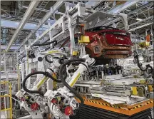  ?? YURI KAGEYAMA / AP ?? Robotic arms put in the electric vehicle powertrain into the Ariya model in the assembly line at Nissan’s Tochigi plant in Kaminokawa town, Tochigi prefecture, Japan, on Friday.