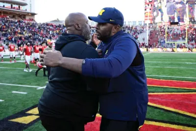  ?? (AP Photo/nick Wass, File) ?? Michigan acting head coach Sherrone Moore, right, and Maryland head coach Mike Locksley, left, greet each other Nov. 18, 2023, after an NCAA college football game in College Park, Md. Locksley is the founder of the National Coalition of Minority Football Coaches.