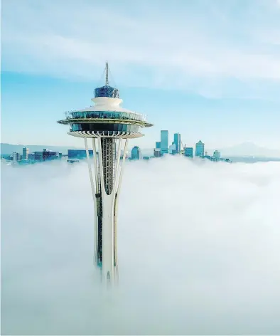  ?? SPACE NEEDLE ?? The top of Seattle’s Space Needle is seen above the clouds, in a photo that also shows some of the renovation­s to the 62-year-old Seattle landmark, which includes tilted open air glass panels on the top observatio­n deck. The next renovation phase is updating its three elevators.