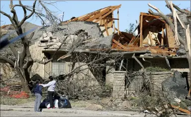  ?? LM OTERO — THE ASSOCIATED PRESS ?? Women stand outside a house damaged by a tornado in the Preston Hollow section of Dallas, Monday.