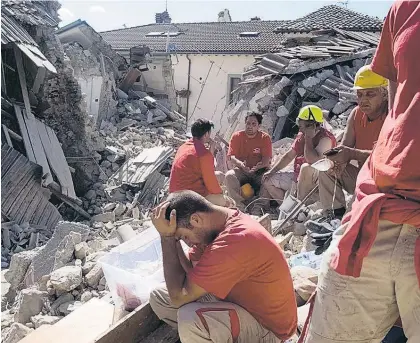  ?? Picture / AP ?? Rescue workers take a quiet moment out from the search effort in Amatrice, one of the worst-hit towns.