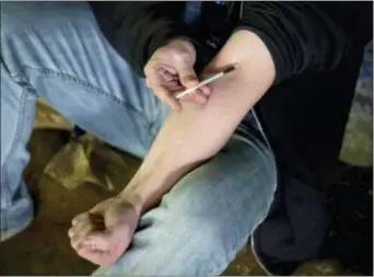  ?? DAVID GOLDMAN — THE ASSOCIATED PRESS FILE ?? A man injects heroin into this arm under a bridge along the Wishkah River at Kurt Cobain Memorial Park in Aberdeen, Wash. Philadelph­ia’s health department announced a new ad campaign Tuesday showcasing how easy naloxone, an opioid-overdose antidote, is to use and urging residents to obtain it.