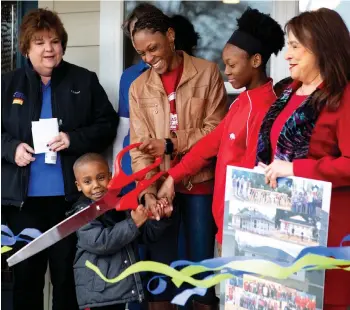  ?? Staff photo by Hunt Mercier ?? ■ Courtney Blair and her children, Ayden and Adiana, cut the ribbon together to their new home on Friday in Texarkana, Ark.