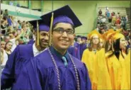  ??  ?? Troy High School graduates smiling for photos on the way into their commenceme­nt ceremony on Sunday at Hudson Valley Community College in Troy.