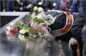  ?? RICHARD DREW — THE ASSOCIATED PRESS ?? Ed Schantz, representi­ng Monica Rodriguez Smith and her unborn daughter, two of the six victims of the World Trade Center bombing, kisses her name on the 9/11 Memorial during the 25th anniversar­y ceremony of the event, in New York, Monday.