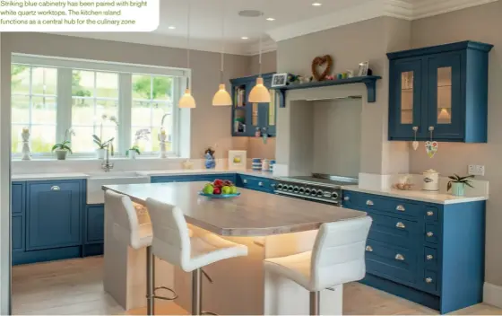  ??  ?? Striking blue cabinetry has been paired with bright white quartz worktops. The kitchen island functions as a central hub for the culinary zone