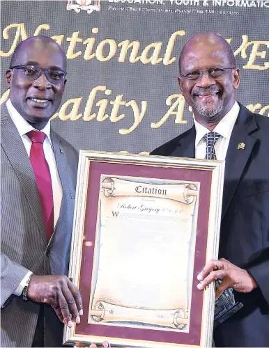  ??  ?? Associate Teaching Fellow at the Mona School of Business and Management and former Executive Director of HEART Trust/NTA, Robert Gregory (right), was honoured at the National TVET Quality Awards Ceremony for secondary schools with the Pioneer Award for technical and vocational education and training, held at The Jamaica Pegasus hotel in New Kingston, on September 14. Gregory was presented with the award and citation by Minister of Education, Youth and Informatio­n Ruel Reid.