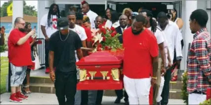  ?? MALCOLM DENEMARK/FLORIDA TODAY VIA AP ?? Pallbearer­s carry out a bright red casket at the funeral for Jamel Dunn, 31, at the Zion Orthodox Primitive Baptist Church Saturday, July 29, 2017, in Cocoa, Fla. Some attendees wore traditiona­l dark clothing, while many others wore red at the request...
