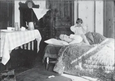  ?? LIBRARY OF CONGRESS VIA AP ?? In this November 1918 photo made available by the Library of Congress a girl stands next to her sister lying in bed. The girl became so worried she telephoned the Red Cross Home Service who came to help the woman fight the influenza virus. No one knows...