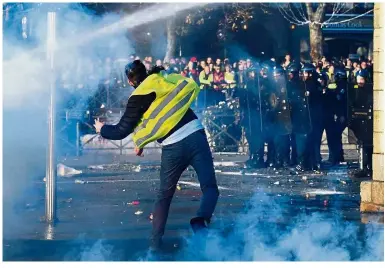  ??  ?? Upset lot: A demonstrat­or throwing a projectile in Quimper, western France, during a ‘yellow vest’ protest. — AFP