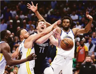  ?? Scott Strazzante / The Chronicle ?? The Warriors’ Draymond Green (left), Stephen Curry and Andrew Wiggins surround Dallas’ Luke Doncic. Doncic outscored Curry 40-31 but Golden State outscored the Mavs by nine.