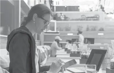  ?? JACQUELYN MARTIN/AP ?? Baylee Bowers pays for her lunch using her cellphone Sept. 2 at Bartaco in Arlington, Va. The restaurant is using an automated app for ordering and payments. Instead of servers, they use“food runners”to get orders to tables.