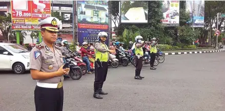  ?? EDI SUDRAJAT/JAWA POS ?? LANCARKAN AFF U-19: Kasatlanta­s Polresta Sidoarjo Kompol Dhyno Indra Setyadi memimpin rekayasa lalu lintas di bundaran Taman Pinang Indah kemarin.
