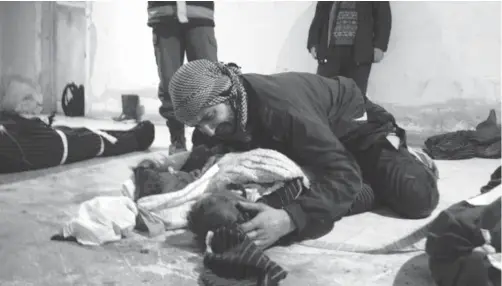  ??  ?? GUTA. Un hombre llora junto al cadáver de su hijo en una morgue improvisad­a en la ciudad de Duma.