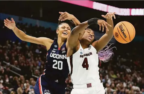  ?? Eric Gay / Associated Press ?? South Carolina’s Aliyah Boston and UConn’s Olivia Nelson-Ododa go after a loose ball during the first half of the national championsh­ip game on Sunday in Minneapoli­s.