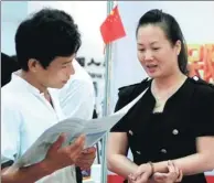  ?? SHI YAN / FOR CHINA DAILY ?? A man examines an insurance policy brochure at an industry expo in Haikou, Hainan province.