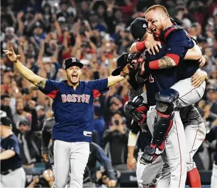  ?? Harry How / Getty Images ?? Red Sox catcher Christian Vazquez hops aboard Chris Sale, who threw the ninth inning to complete Boston’s 5-1 win in Sunday’s Game 5 World Series clincher. Winning pitcher David Price joins the hug while reliever Joe Kelly charges in at left.