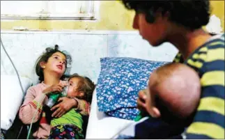  ?? HASAN MOHAMED/AFP ?? A Syrian girl holds an oxygen mask over the face of an infant at a make-shift hospital following a reported gas attack on the rebel-held besieged town of Douma in the eastern Ghouta region on the outskirts of the capital Damascus on January 22.