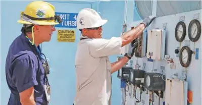  ?? ?? HOMESTEAD: Juan Madruga, left, and Pehter Rodriguez, right, of Florida Power and Light work on the Turkey Point Nuclear Reactor in Homestead, Florida.