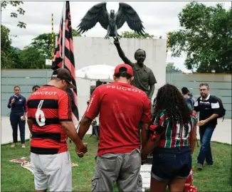  ?? The Associated Press ?? Fans hold hands as they pray Friday in an homage to the victims of a fire at the Flamengo soccer club training complex in Rio de Janeiro, Brazil.