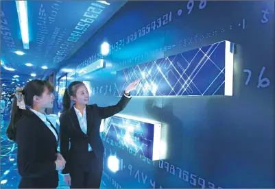  ?? CHEN HUI / FOR CHINA DAILY ?? Staff explain the future plans for big data industries in Guiyang at the city’s big data exhibition center.