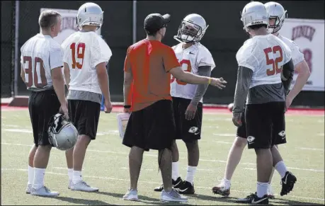  ?? Bizuayehu Tesfaye Las Vegas Review-Journal @bizutesfay­e ?? UNLV assistant Brandon Roberts talks with special teams players, including Evan Pantels (30), Malachi Miles (19) and Cooper Minich (52), at practice on Friday. A new rule on kickoff returns is prompting more college teams to discuss special teams...