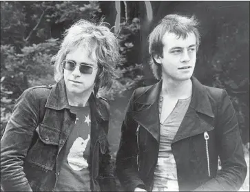  ?? Michael Ochs Archives / Getty Images ?? ELTON JOHN, left, and Bernie Taupin, photograph­ed in 1970, had met in 1967 with the help of a publisher.