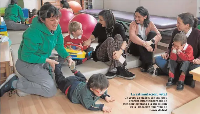  ??  ?? Un grupo de madres con sus hijos charlan durante la jornada de atención temprana a la que asisten en la Fundación Síndrome de Down Madrid