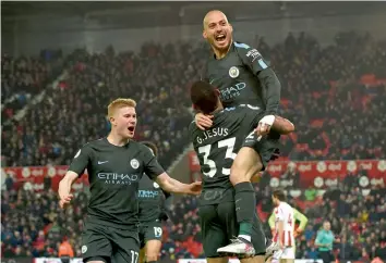  ?? — AFP ?? Manchester City’s David Silva ( right) celebrates with team mates after scoring against Stoke City in their English Premier League match at the Bet365 Stadium in Stoke- on- Trent on Monday. Manchester City won 2- 0.