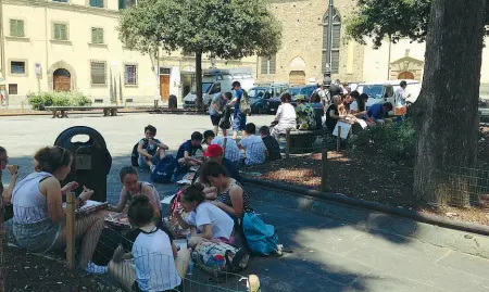  ??  ?? Santo Spirito Una scolaresca con cartoni di pizza e bibite accampata nell’ombra tra due aiuole in piazza