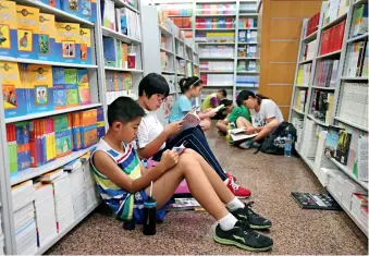  ??  ?? Des parents et enfants à la librairie Xinhua située sur l’avenue Wangfujing